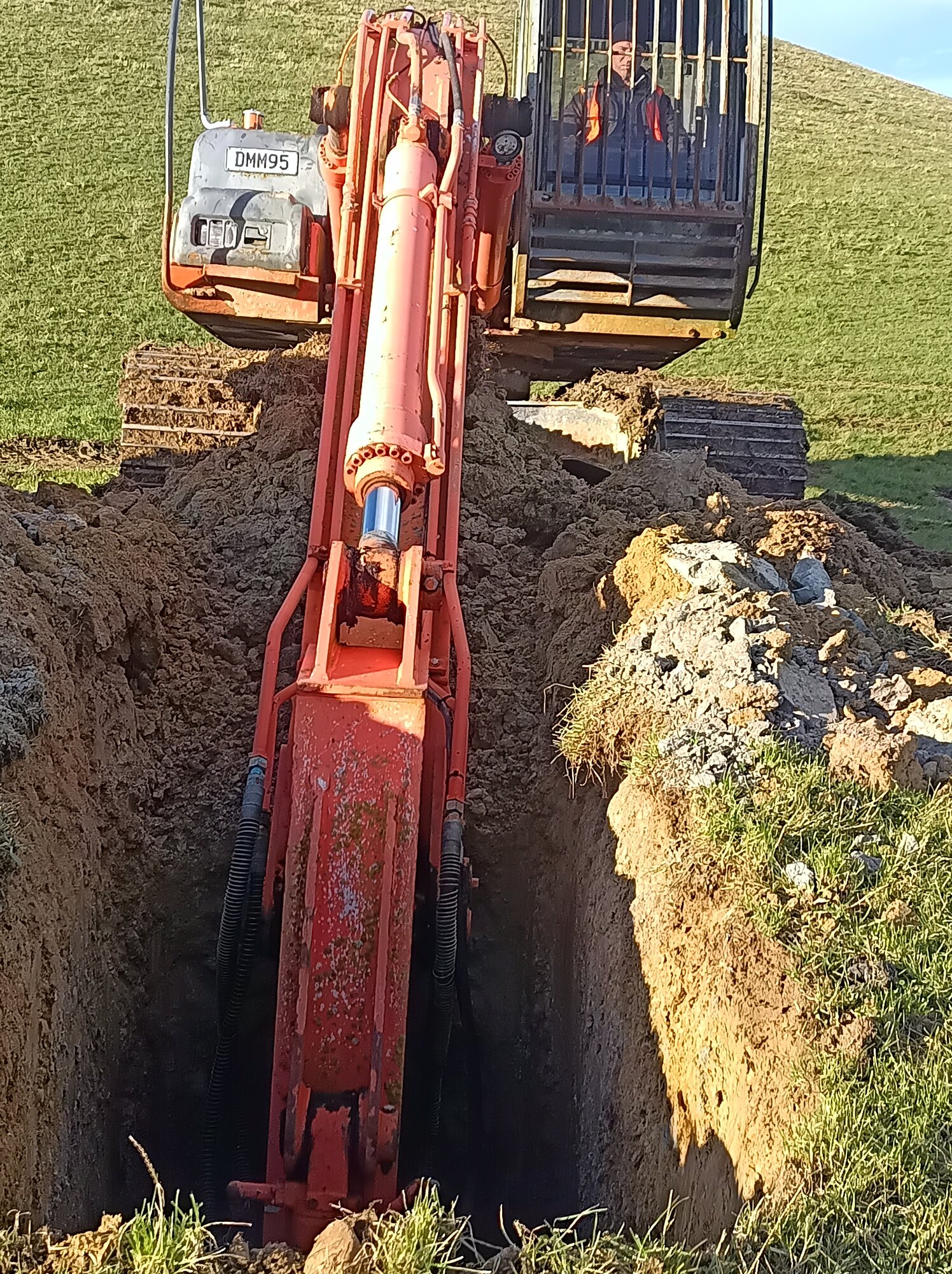 Excavator exposing an alluvial geological section in Otago